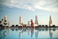 a woman in a red dress standing in a swimming pool