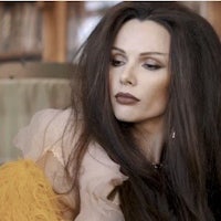 a woman with long hair sitting on a couch