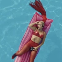 a woman in a red bikini laying in a pool