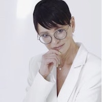 a woman wearing glasses and a white blazer