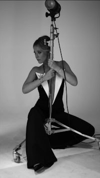 a black and white photo of a woman sitting on a tripod