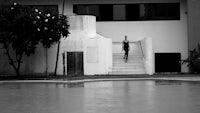 a black and white photo of a person standing next to a pool