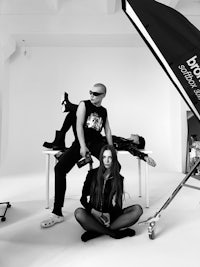 a black and white photo of a man and woman posing in front of a camera