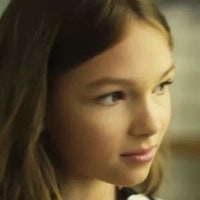 a young girl in a black and white shirt is staring at something