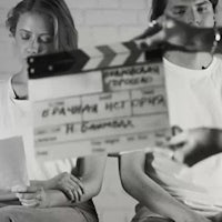 black and white photo of a man and woman holding a clapper board